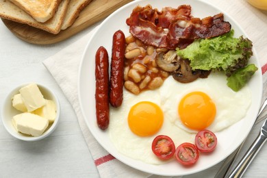 Delicious breakfast with sunny side up eggs served on white table, flat lay