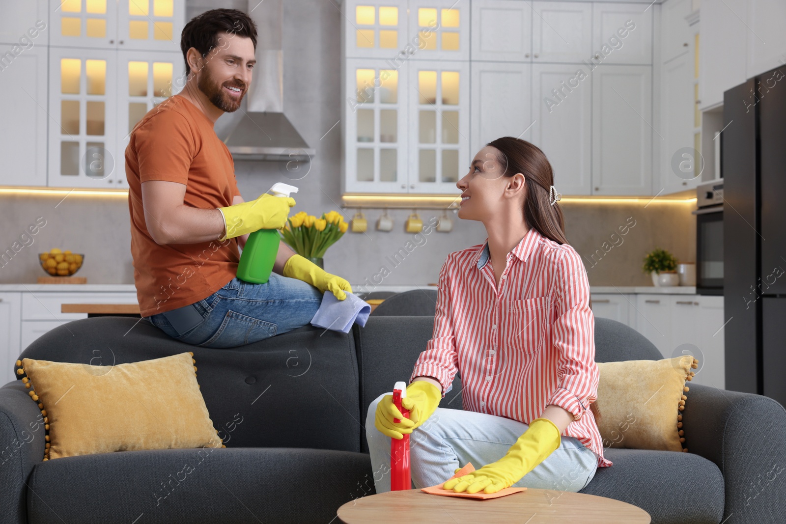 Photo of Spring cleaning. Lovely couple tidying up living room together