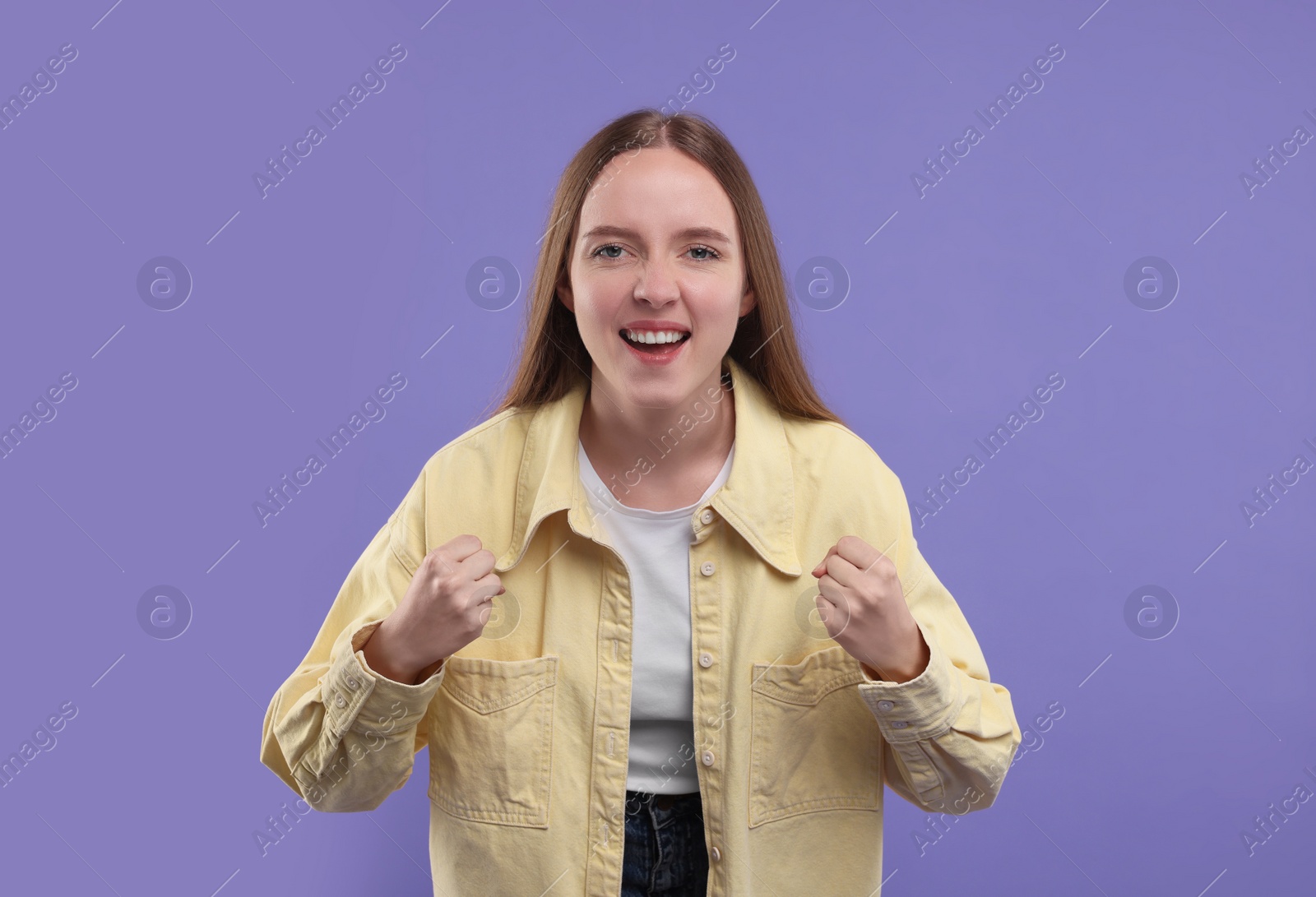 Photo of Emotional sports fan celebrating on purple background