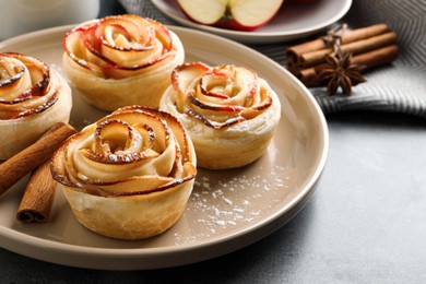 Photo of Freshly baked apple roses on grey table. Beautiful dessert