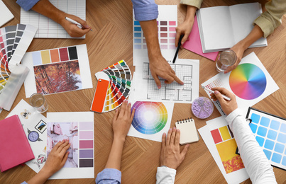 Photo of Professional team of interior designers working at table, top view