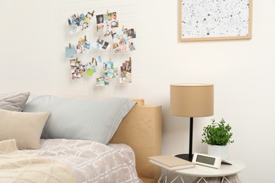 Photo of Stylish room interior with comfortable bed and vision board on wall