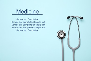 Stethoscope on light blue background, top view. Space for text