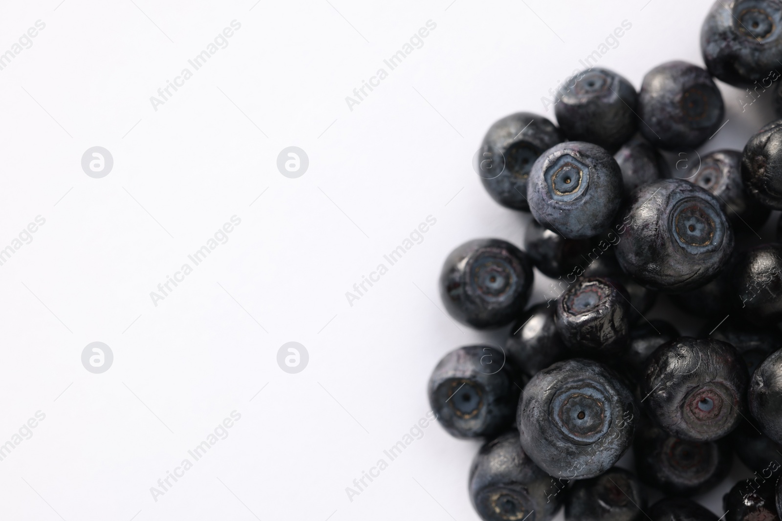 Photo of Pile of ripe bilberries on white background, closeup. Space for text