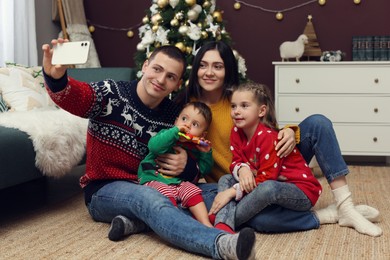 Photo of Happy family taking selfie in room decorated for Christmas