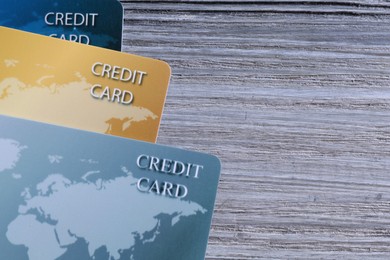 Photo of Credit cards on grey wooden table, flat lay. Space for text