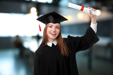 Image of Happy student with graduation hat and diploma in office