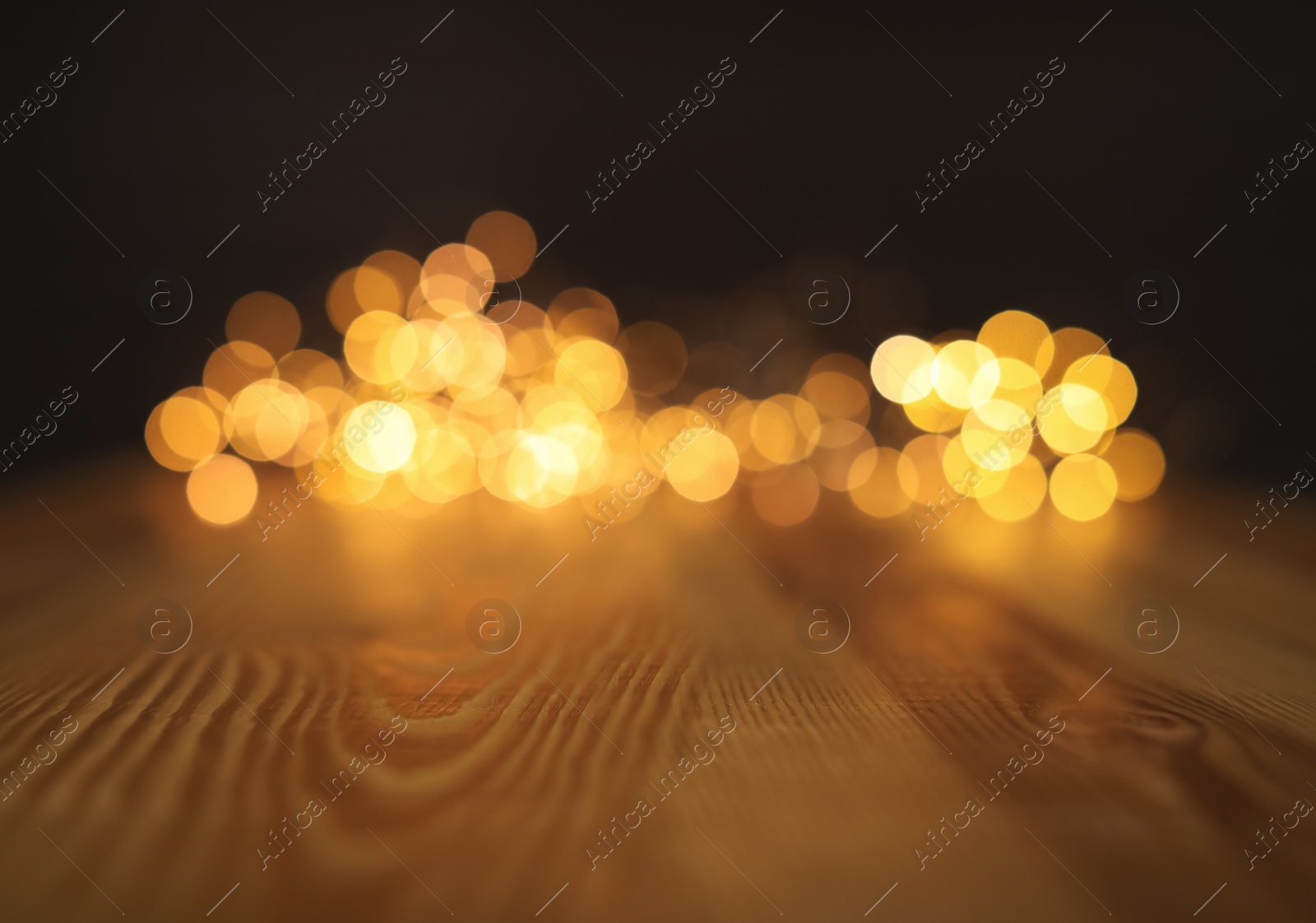 Photo of Empty wooden surface and blurred lights on background. Bokeh effect