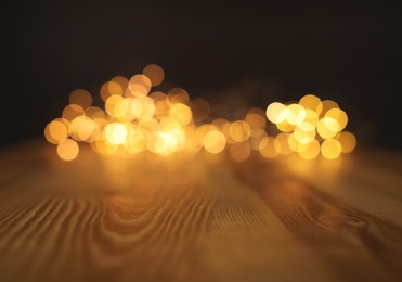 Photo of Empty wooden surface and blurred lights on background. Bokeh effect