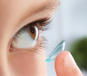 Photo of Little child putting contact lens into his eye, closeup