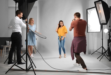 Photo of Professional team working with model in photo studio