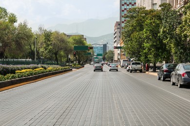 Photo of City street with cars and modern buildings