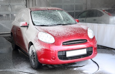 Photo of Cleaning automobile with high pressure water jet at car wash