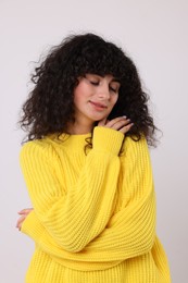 Photo of Young woman in stylish yellow sweater on white background