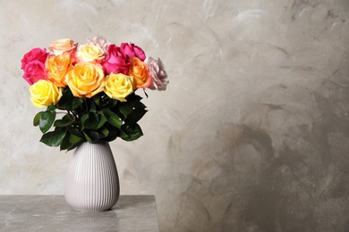 Photo of Luxury bouquet of fresh roses on grey table. Space for text