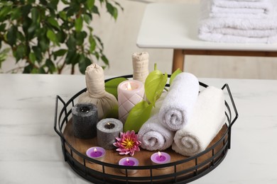 Photo of Composition with different spa products and burning candles on white marble table indoors