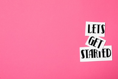 Photo of Sheets of paper with phrase Let's Get Started on pink background, flat lay. Space for text