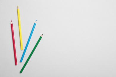 Photo of Colorful pencils on light background, flat lay. Space for text