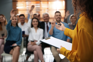 Photo of Business trainer answering questions at seminar in conference hall