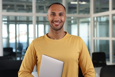 Photo of Handsome happy man with laptop in office
