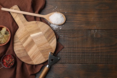 Photo of Cooking utensils with different spices on wooden table, flat lay. Space for text