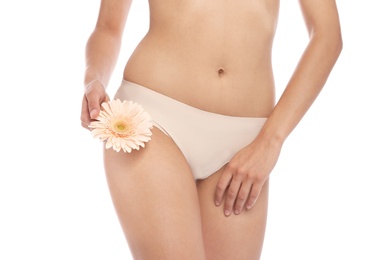 Photo of Young woman with flower showing smooth skin after bikini epilation on white background