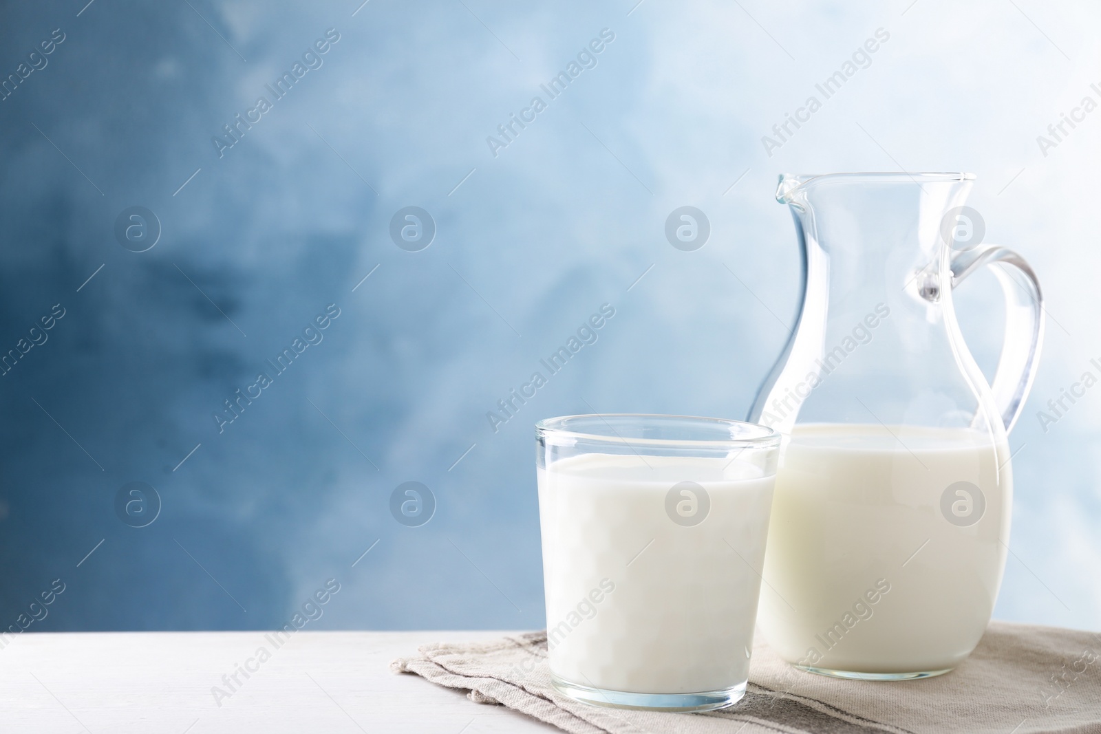 Photo of Delicious fresh milk on white table. Space for text