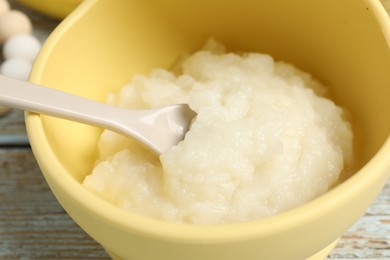 Photo of Baby food. Bowl with cauliflower puree on rustic wooden table, closeup