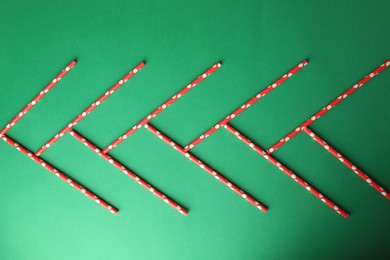 Photo of Paper drinking straws on green background, flat lay