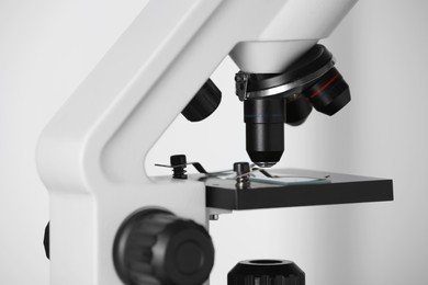 Photo of Modern microscope on light background, closeup. Medical equipment
