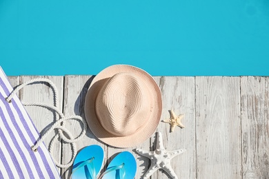 Photo of Beach accessories on wooden deck near outdoor swimming pool, flat lay. Space for text