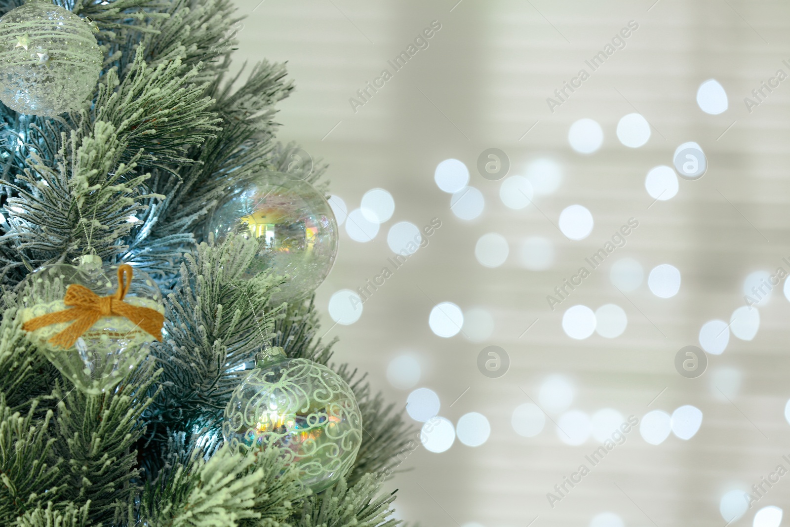 Photo of Decorated Christmas tree against blurred festive lights, closeup. Space for text