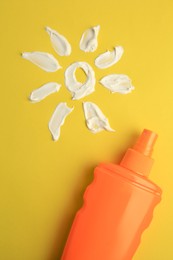 Photo of Drawing of sun and bottle with sunscreen on yellow background, top view. Skin protection