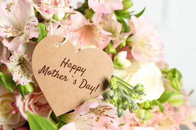 Image of Happy Mother's Day. Heart shaped greeting label and beautiful flowers