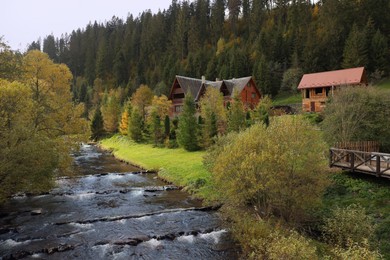 Photo of Beautiful view of forest and village near river on autumn day