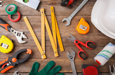 Photo of Flat lay composition with construction tools on wooden background