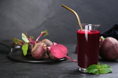 Photo of Freshly made beet juice on black table. Space for text
