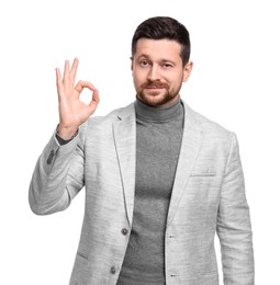 Photo of Handsome bearded businessman in suit showing OK gesture on white background