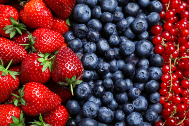 Photo of Mix of different ripe tasty berries as background, top view