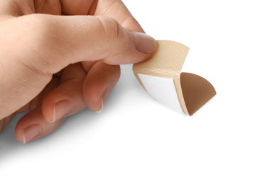 Photo of Woman putting sticking plaster on white background. First aid item