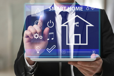 Image of Woman using tablet to set indoor air humidity, closeup. Smart home automation system