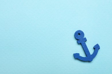 Photo of Anchor figure on pale blue background, top view. Space for text