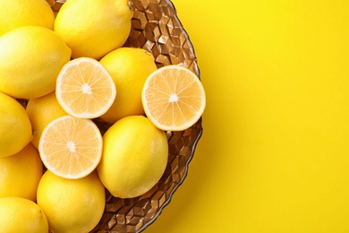 Photo of Fresh lemons on yellow background, top view. Space for text