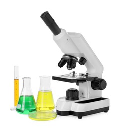 Photo of Laboratory glassware with colorful liquids and microscope isolated on white