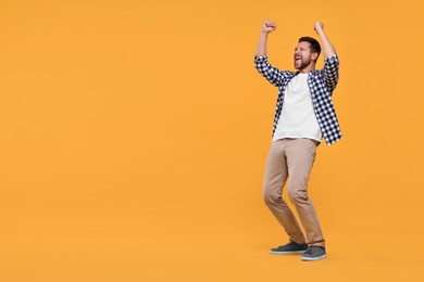Photo of Emotional sports fan celebrating on yellow background. Space for text