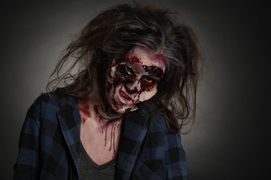 Photo of Scary zombie on dark background. Halloween monster