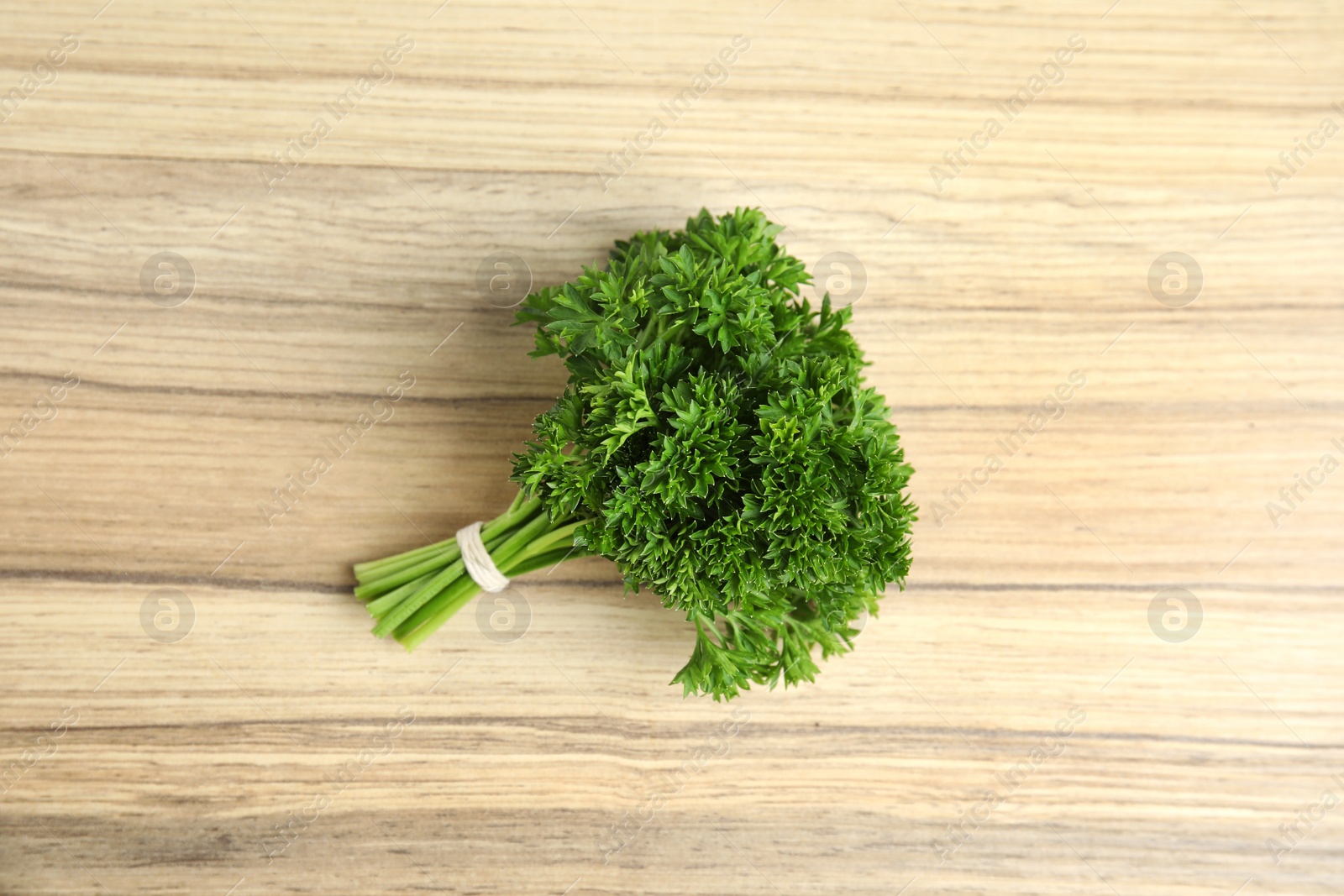 Photo of Bunch of fresh green parsley on wooden background, top view