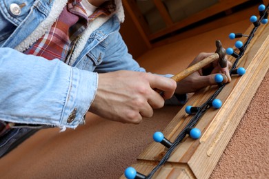 Photo of Man decorating house with Christmas lights outdoors, closeup