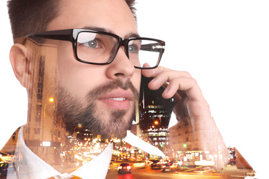 Image of Double exposure of businessman talking on phone and night city landscape