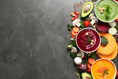 Photo of Various cream soups, ingredients and space for text on grey background, flat lay. Healthy food